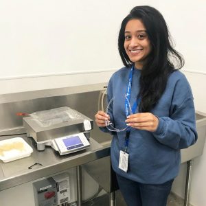 Nidhi Menon stands in a lab at Fresenius.