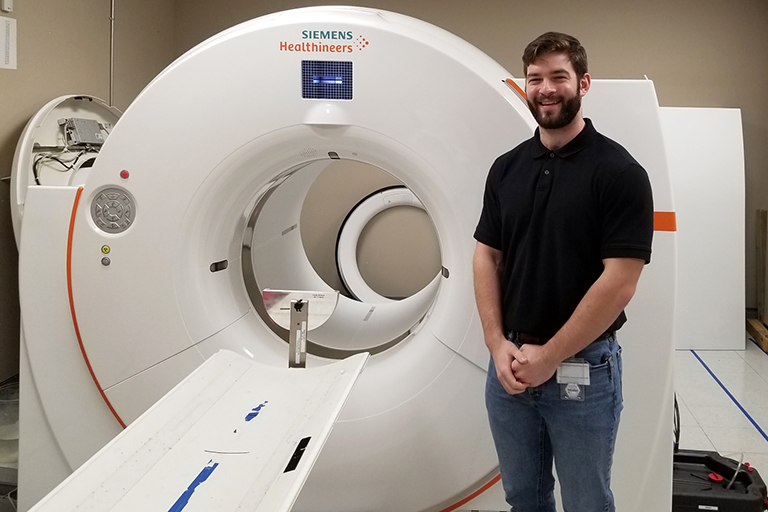 Wilton Chapman stands beside an CT machine.
