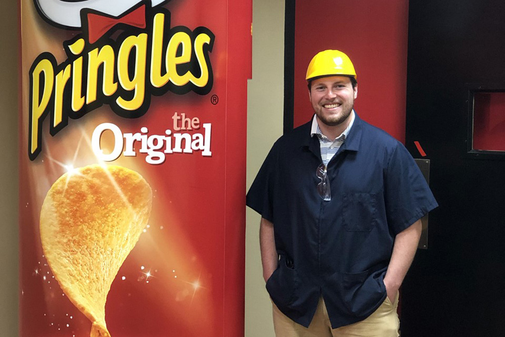 Tyler Corum beside a large Pringles can.