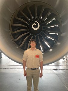 Christopher Schenck stands in front of a jet engine attached to one of the many aircraft that UPS use to deliver their customer's products.